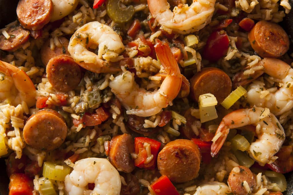 A close-up of jambalaya with shrimp, sliced smoked sausage, rice, celery and red bell pepper
