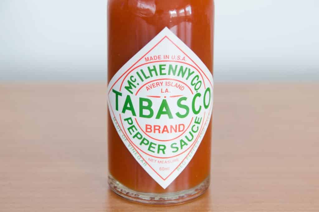 A bottle of Tabasco brand pepper sauce on a wooden table